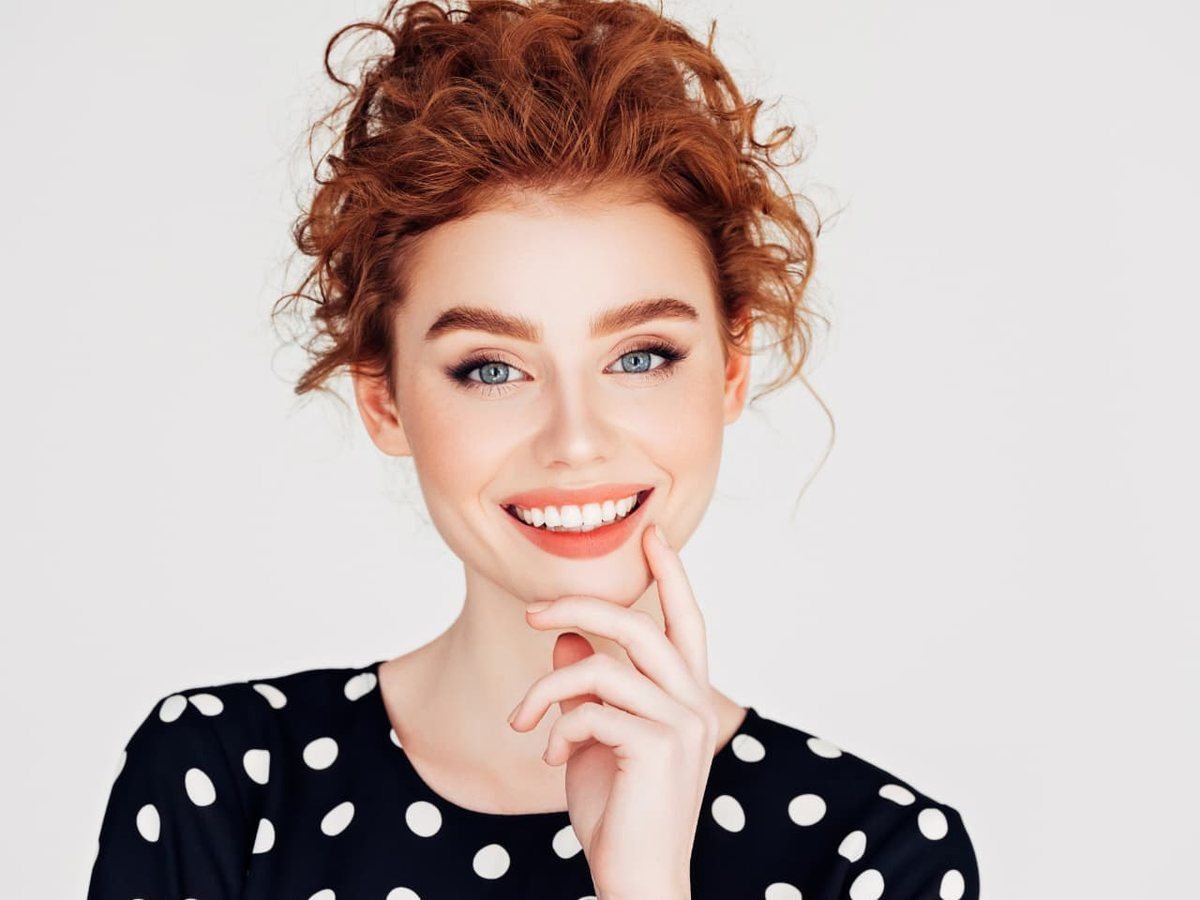 Mujer con una sonrisa amplia y natural (imagen ilustrativa)